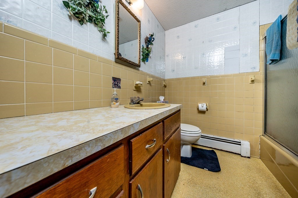 231 Monomoy Circle Barnstable, MA 02632 - Photo 18 of 28 a bathroom with a granite countertop sink a toilet and shower