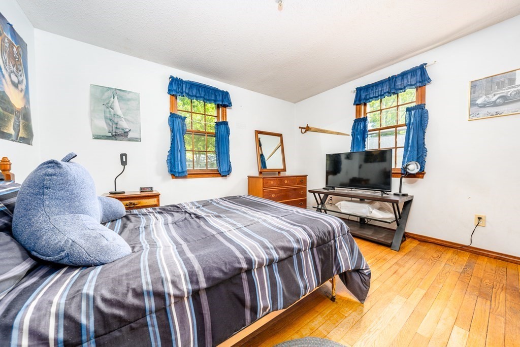 231 Monomoy Circle Barnstable, MA 02632 - Photo 22 of 28 a bedroom with a bed and a flat screen tv