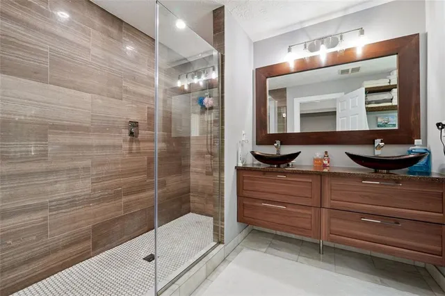 a bathroom with a granite countertop sink a toilet and shower