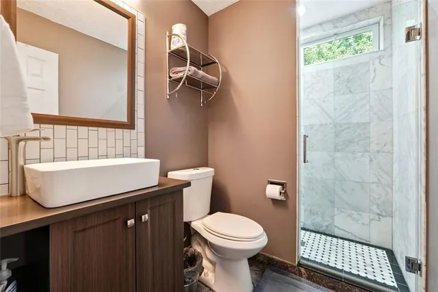 a bathroom with a sink a toilet and shower