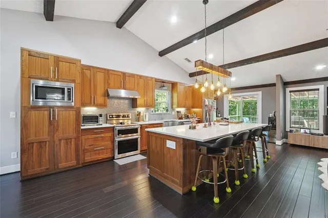 a kitchen with stainless steel appliances granite countertop a stove and a refrigerator