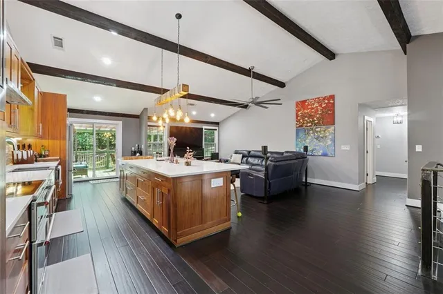 a kitchen with stainless steel appliances granite countertop a lot of counter space and wooden floors