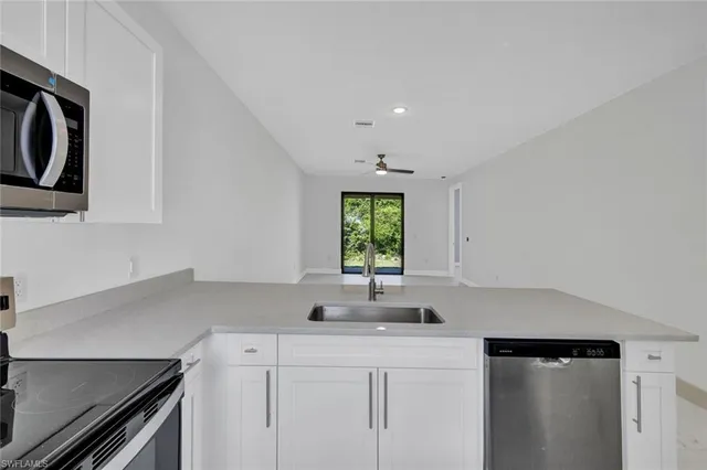 a kitchen with stainless steel appliances granite countertop a refrigerator sink and stove