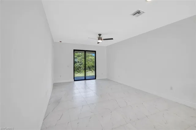 a large white kitchen with kitchen island granite countertop a sink and a refrigerator