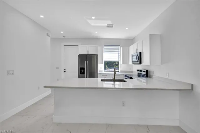 a kitchen with a sink stove and microwave