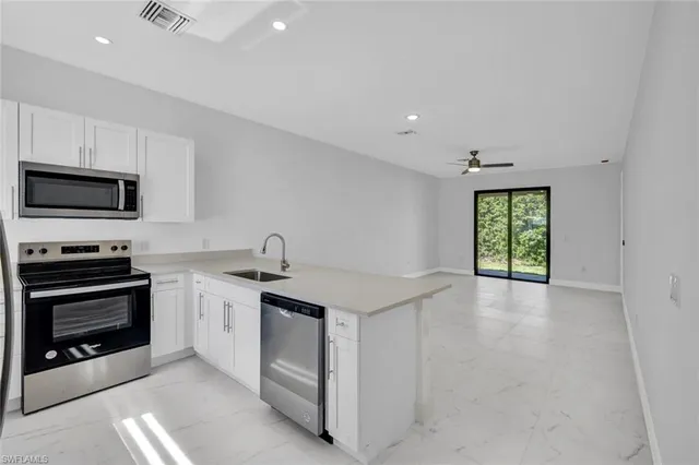 a kitchen with stainless steel appliances granite countertop a stove sink and refrigerator