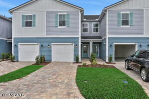 a view of a house with a yard and lawn chairs