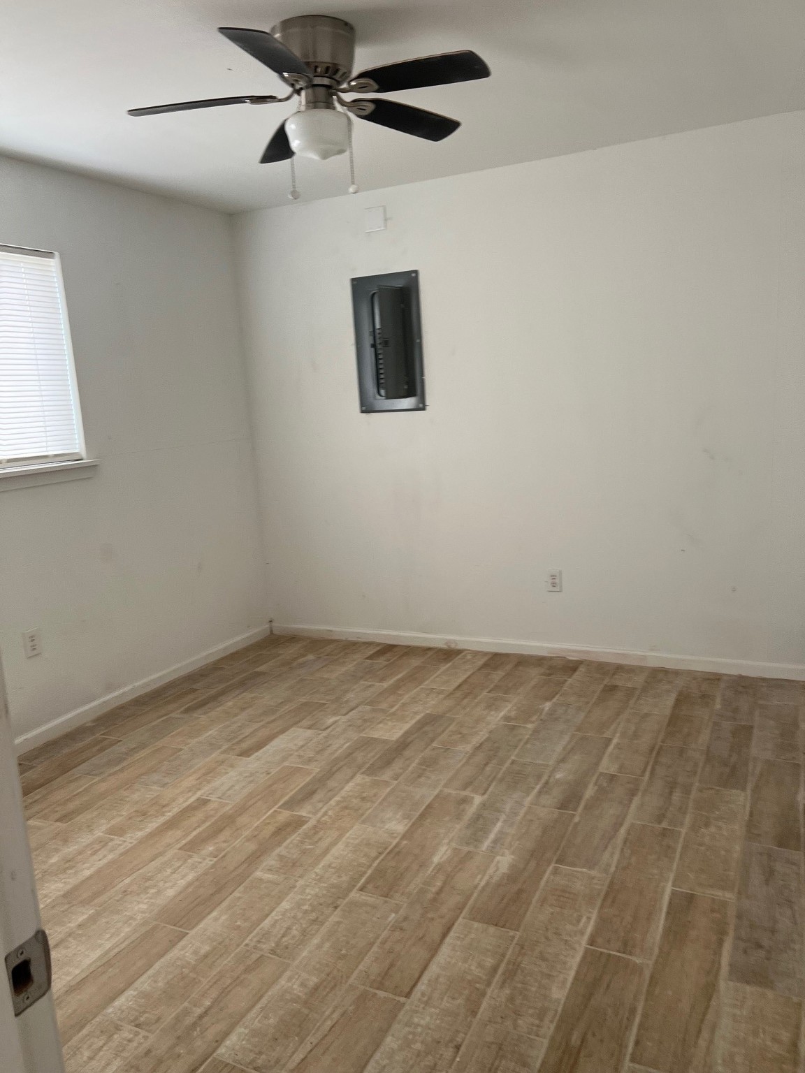 4242 10th Avenue Port Arthur, TX 77642 - Photo 11 of 13 an empty room with a ceiling fan and a window
