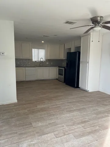 a view of kitchen with refrigerator and window