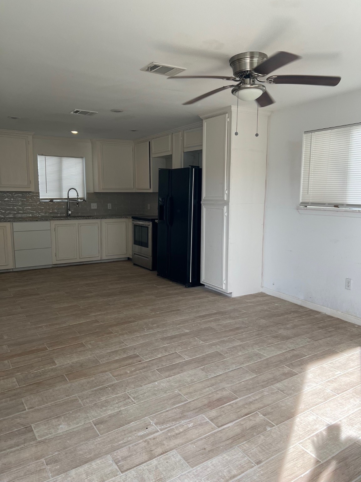 4242 10th Avenue Port Arthur, TX 77642 - Photo 4 of 13 a view of kitchen and empty room with wooden floor