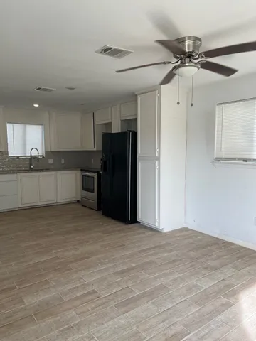 a view of a kitchen with a sink and a refrigerator