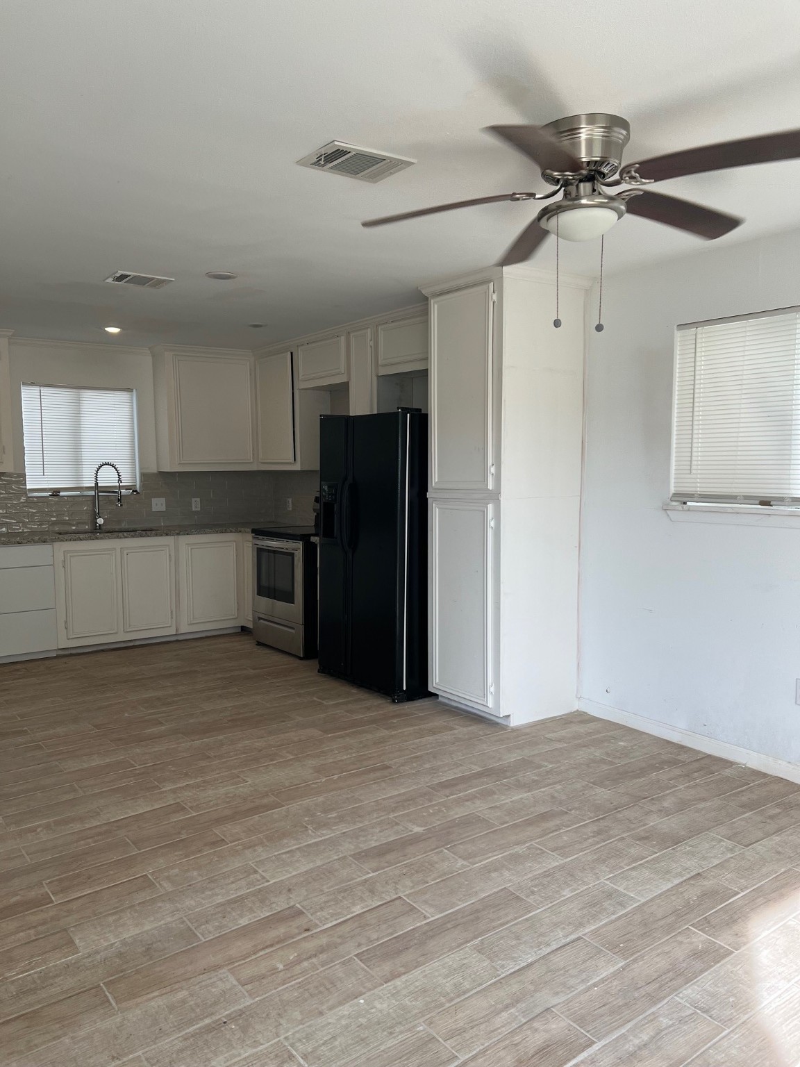 4242 10th Avenue Port Arthur, TX 77642 - Photo 6 of 13 a view of a kitchen with a sink and a refrigerator