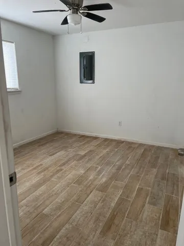 an empty room with a ceiling fan and carpet