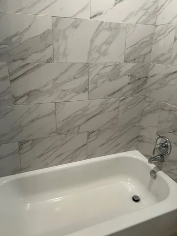 a bathroom with a white bath tub and a shower