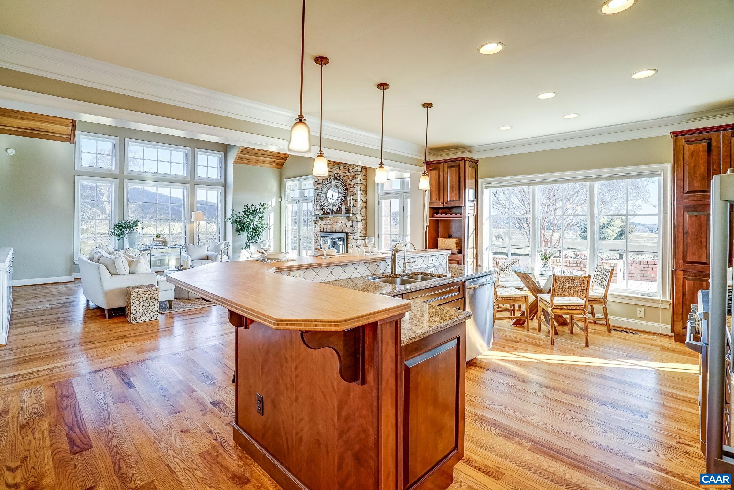 801 Half Mile Branch Road Crozet, VA 22932 - Photo 18 of 69 a dining hall with stainless steel appliances granite countertop a stove top oven a dining table and chairs with wooden floor