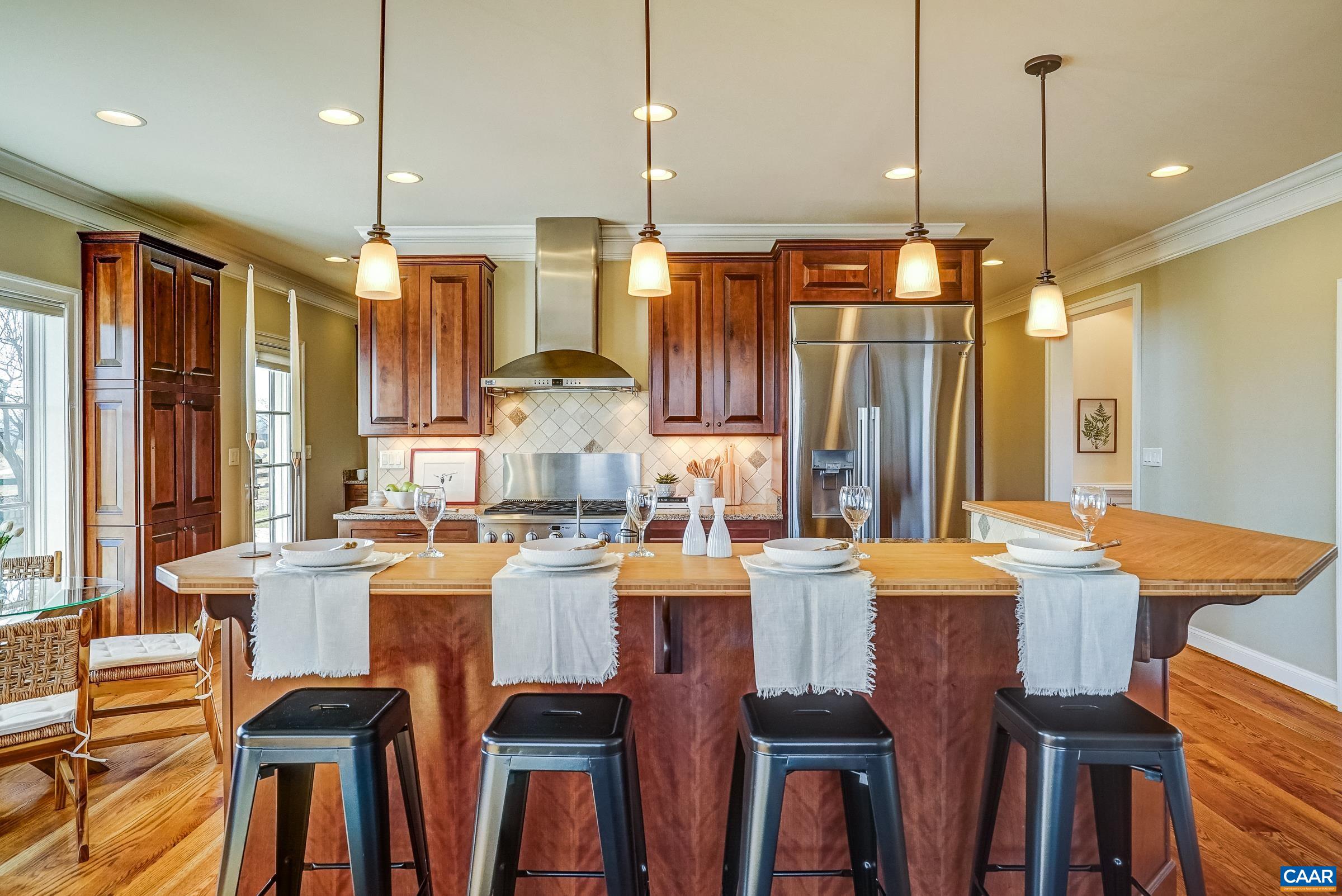 801 Half Mile Branch Road Crozet, VA 22932 - Photo 19 of 69 a kitchen with granite countertop a dining table chairs and white cabinets