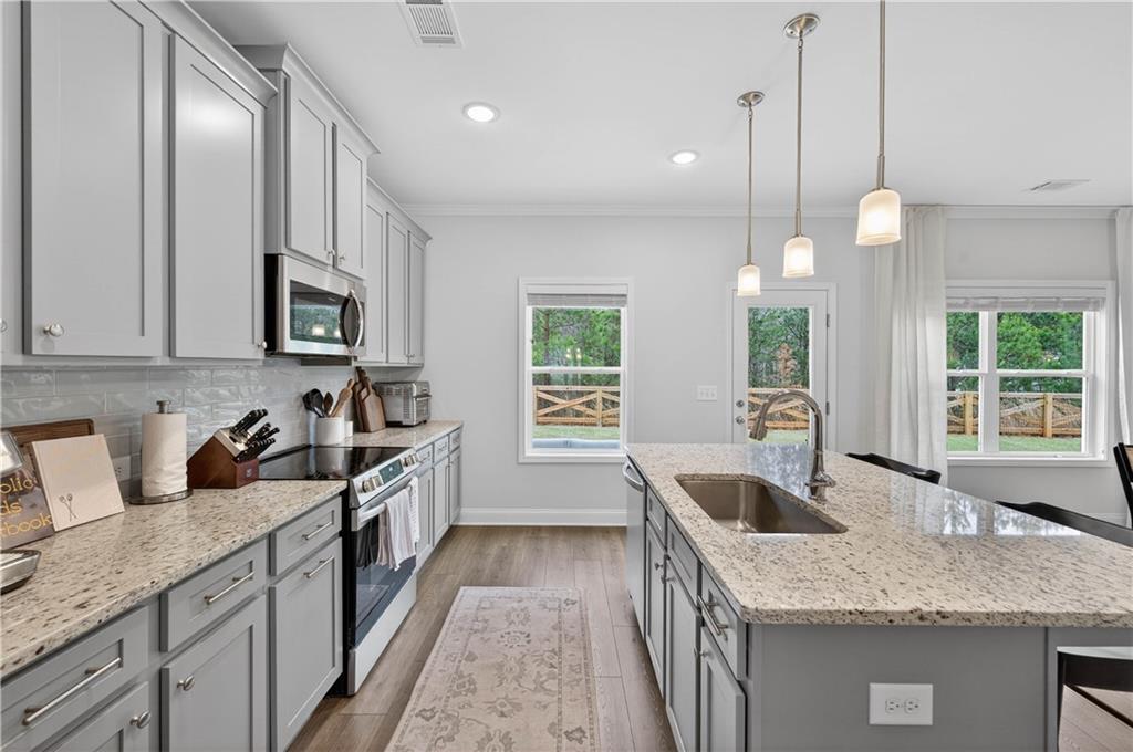 223 Timber Ridge Dawsonville, GA 30534 - Photo 11 of 24 a kitchen with stainless steel appliances granite countertop a sink a stove and a wooden floors