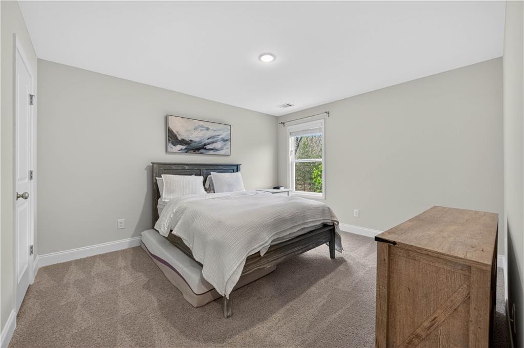 223 Timber Ridge Dawsonville, GA 30534 - Photo 19 of 24 a bedroom with a bed and a painting on the wall