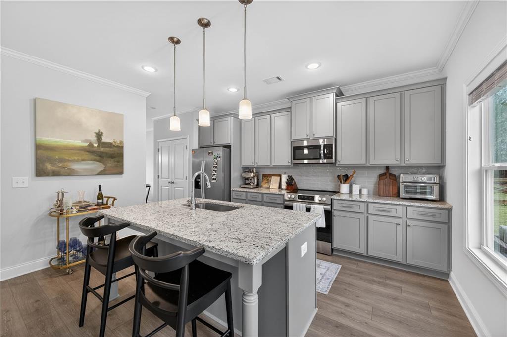 223 Timber Ridge Dawsonville, GA 30534 - Photo 9 of 24 a kitchen with a stove a sink a counter space and a center island