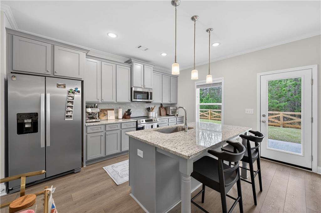 223 Timber Ridge Dawsonville, GA 30534 - Photo 10 of 24 a kitchen with kitchen island a refrigerator a stove a dining table and chairs