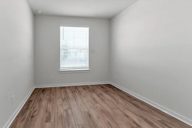wooden floor in an empty room with a window