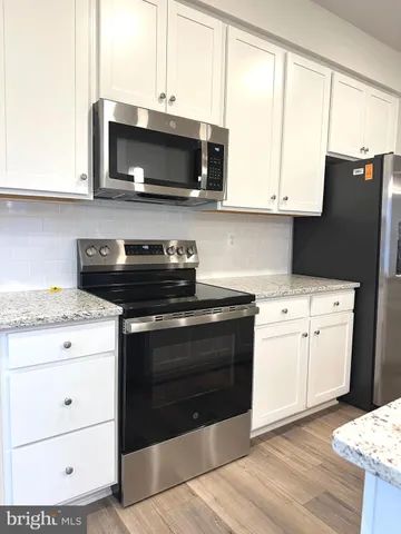 a kitchen with stainless steel appliances a stove microwave and sink