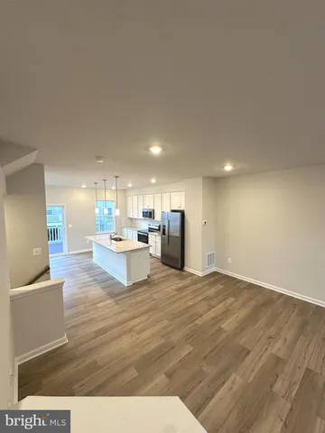 a large kitchen with kitchen island white cabinets and stainless steel appliances