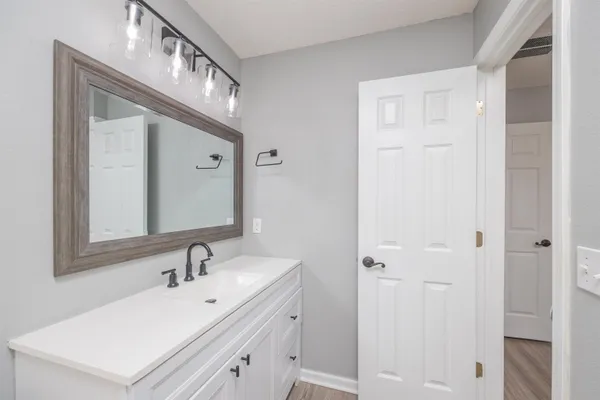 a bathroom with a sink vanity and a mirror