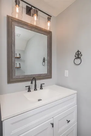 a bathroom with a sink vanity and mirror
