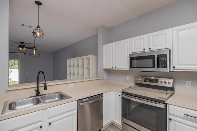 a kitchen with stainless steel appliances granite countertop a sink stove and microwave