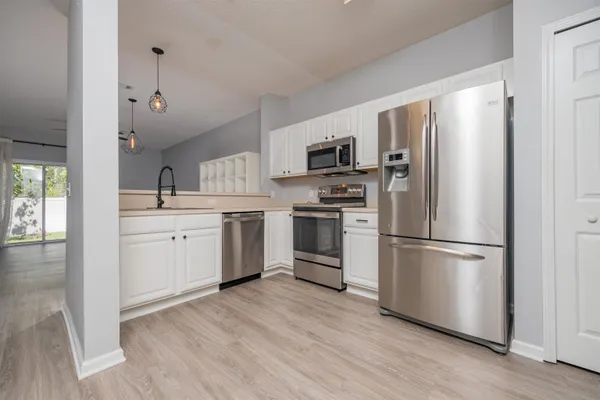 a kitchen with stainless steel appliances a refrigerator sink and cabinets