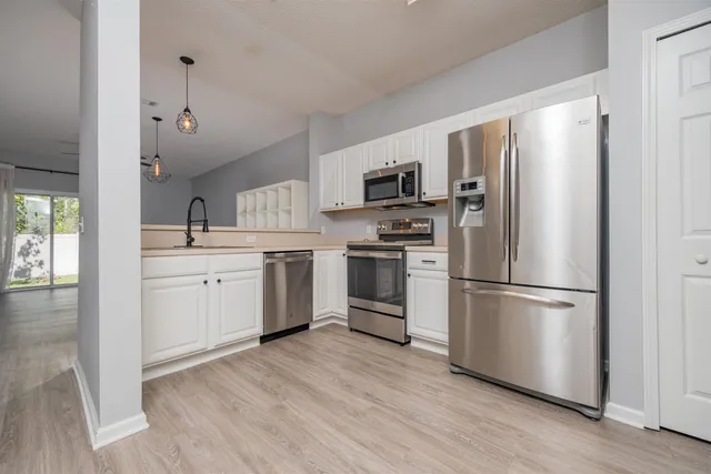 a kitchen with stainless steel appliances a refrigerator sink and cabinets
