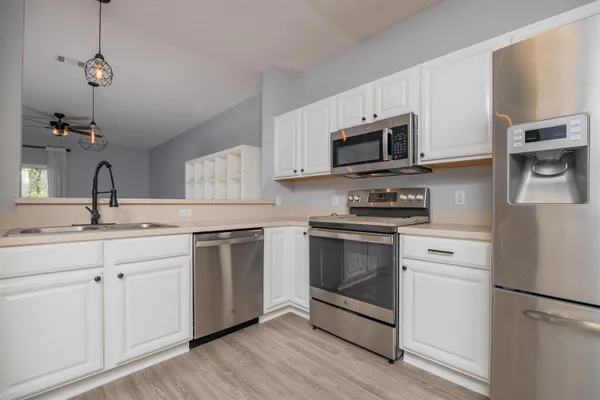 a kitchen with stainless steel appliances granite countertop a stove a sink and a microwave
