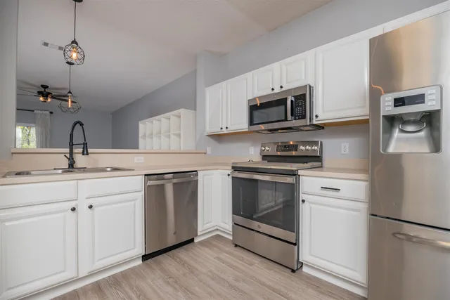 a kitchen with stainless steel appliances granite countertop a stove a sink and a microwave