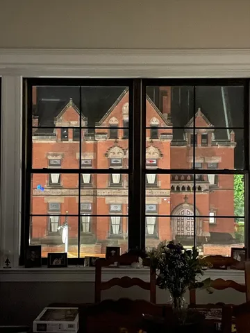 a room with a large window and wooden floor