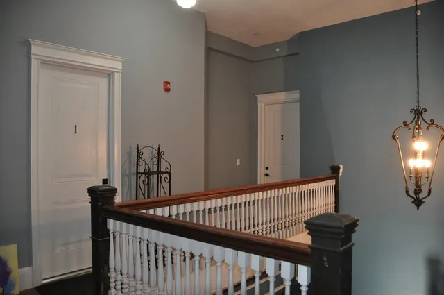 a view of a hallway with wooden floor and windows