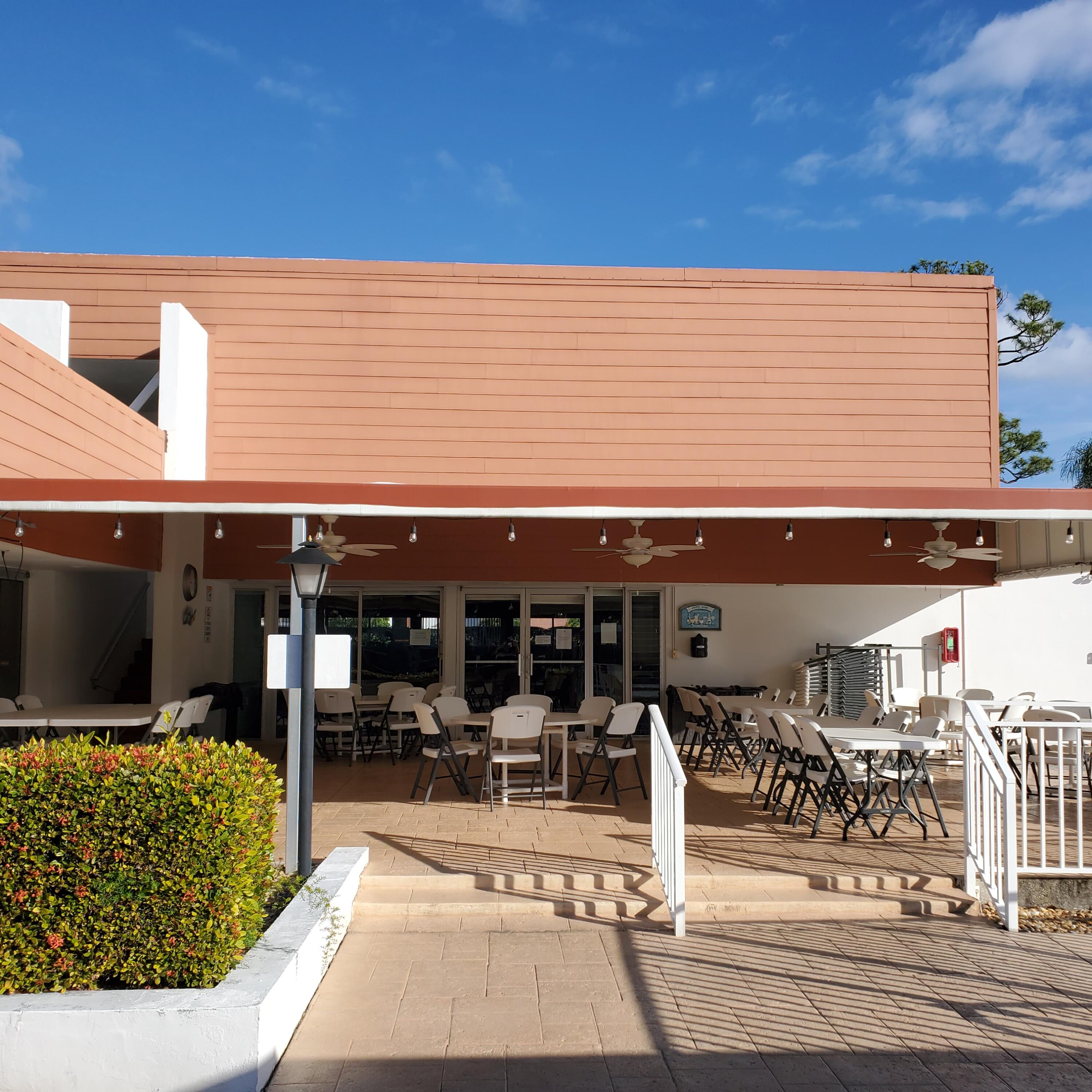 2600 Southeast Ocean Boulevard, Unit A11 Stuart, FL 34996 - Photo 55 of 62 a view of a patio with table and chairs potted plants and large tree