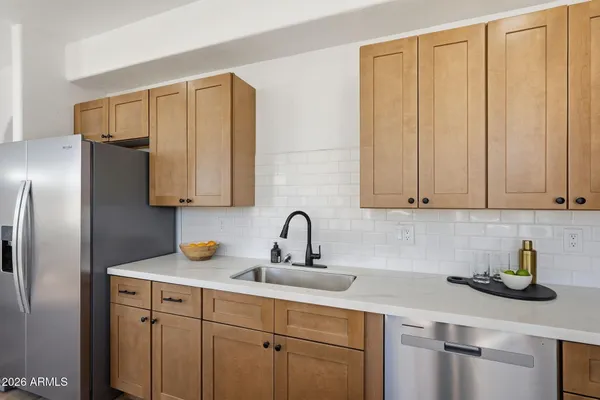 a kitchen with stainless steel appliances granite countertop a sink a refrigerator and cabinets