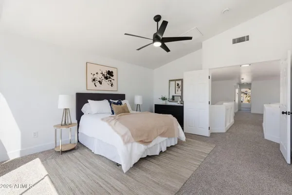 a spacious bedroom with a bed and a ceiling fan