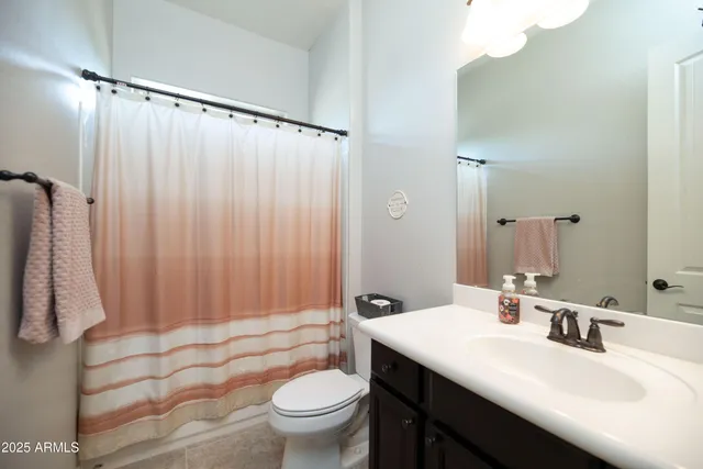 a bathroom with a sink a toilet and shower curtain