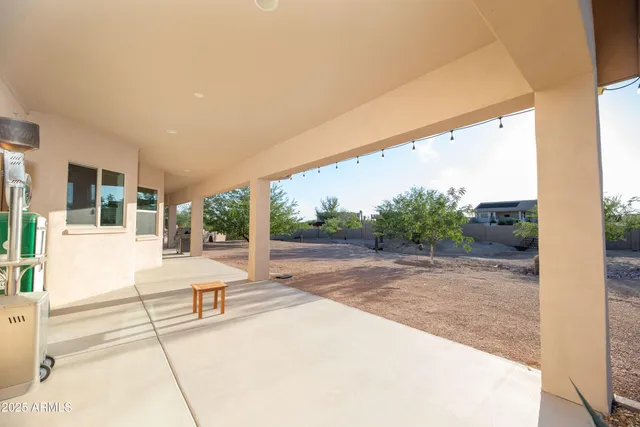 a view of a patio with wooden floor and iron fence