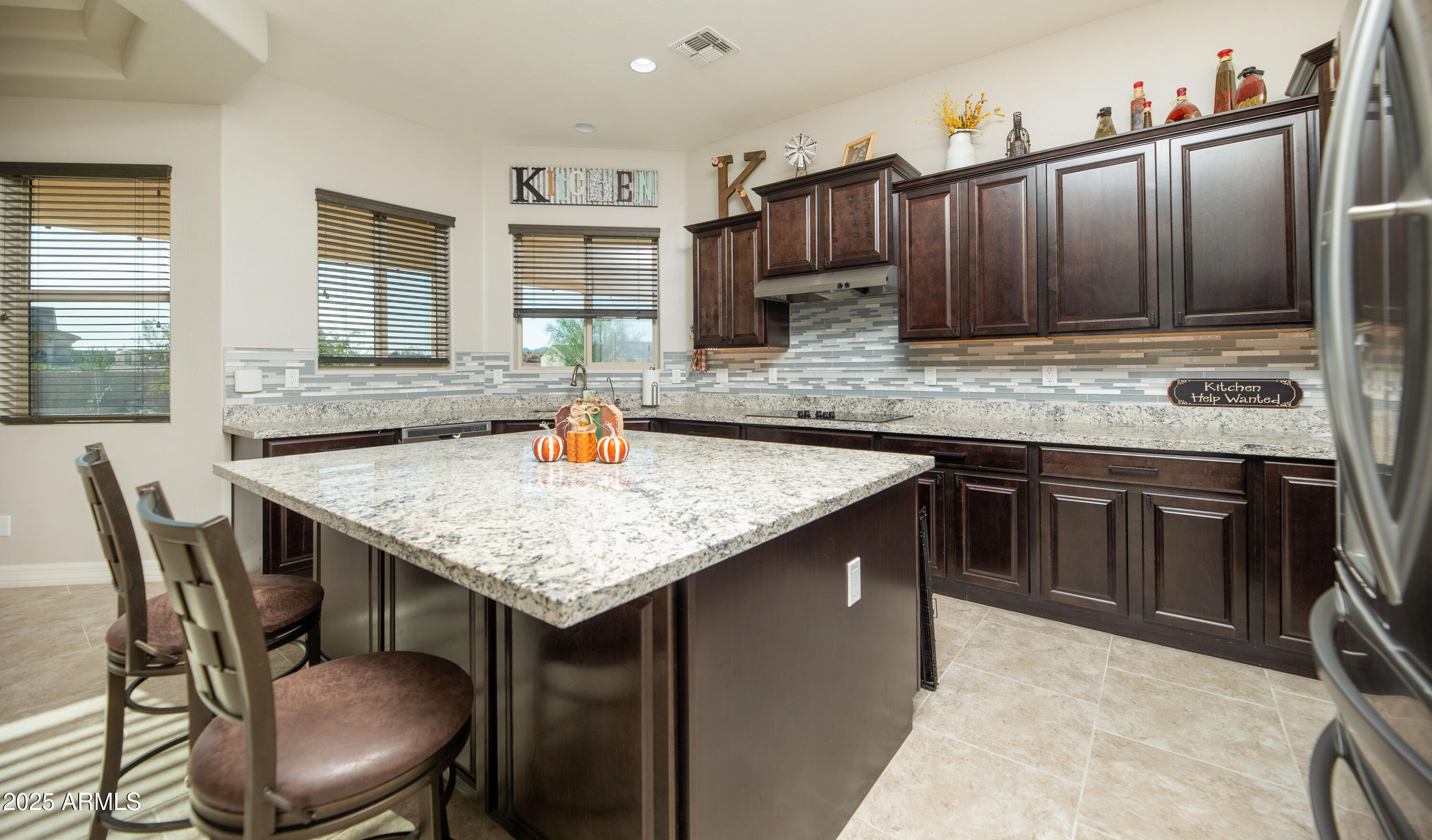 1532 North Roadrunner Road Apache Junction, AZ 85119 - Photo 8 of 54 a kitchen with granite countertop a sink chairs and wooden cabinets