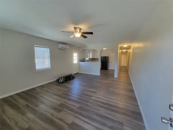 a view of empty room with wooden floor and ceiling fan