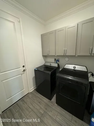 a utility room with wooden floor washer and dryer