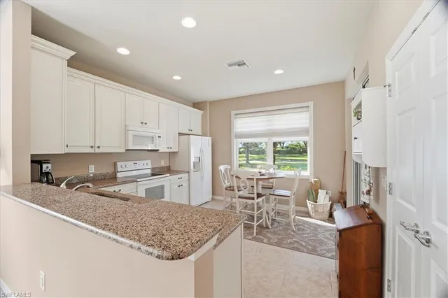 a kitchen with stainless steel appliances granite countertop sink refrigerator and window