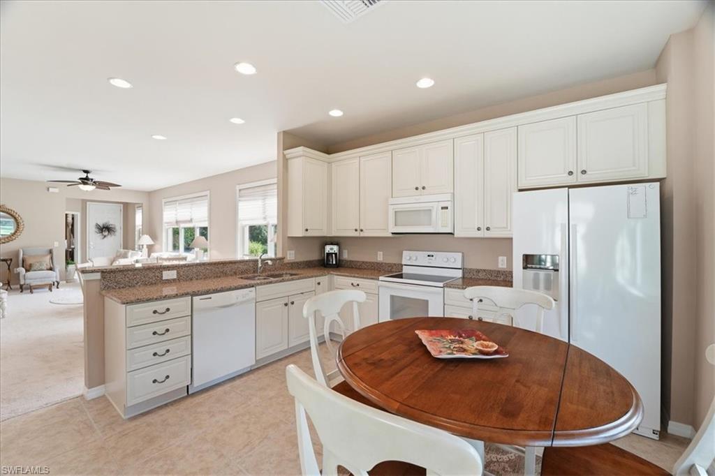 7933 Guadiana Way Ave Maria, FL 34142 - Photo 17 of 50 a kitchen with stainless steel appliances granite countertop a sink a stove a refrigerator a center island and a stove