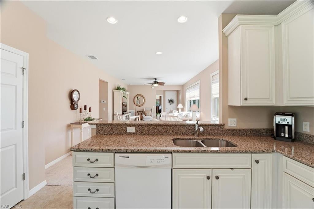 7933 Guadiana Way Ave Maria, FL 34142 - Photo 19 of 50 a kitchen with granite countertop a sink cabinets and stainless steel appliances