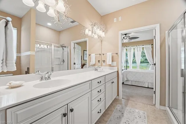 a bathroom with a double vanity sink mirror and next to a window