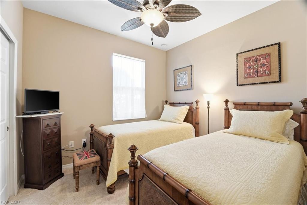 7933 Guadiana Way Ave Maria, FL 34142 - Photo 26 of 50 a bedroom with two bed and a chandelier