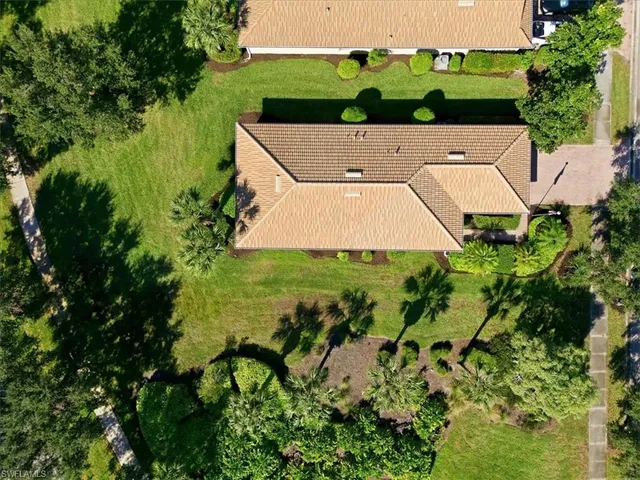 an aerial view of a house with swimming pool garden and trees
